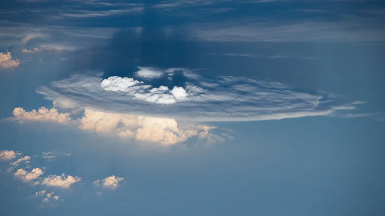 a diagram of convective mass flux over a picture of a thunderstorm