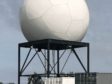 A picture of a white radome that contains the CHIVO radar.